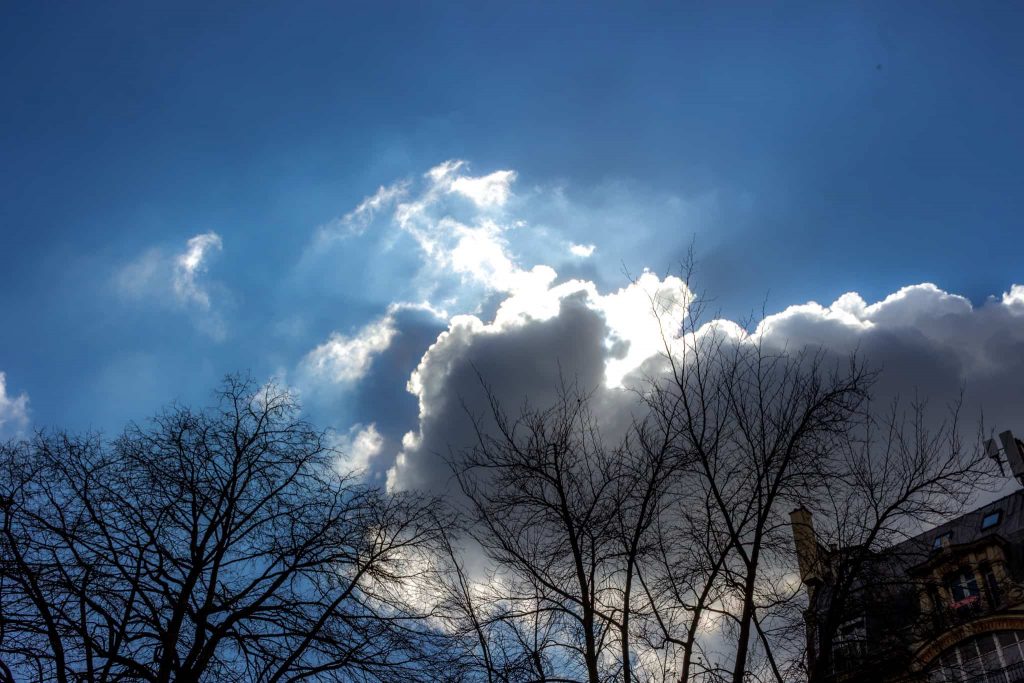 image du ciel, soleil se cachant derrière les nuages